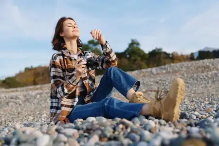 Женщина отдыхает на природе на пляже среди гальки