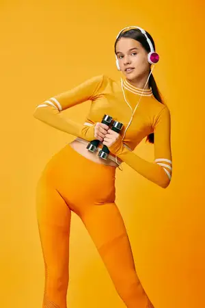 Спортивная женщина-атлет демонстрирует фактурный топ и леггинсы для активного отдыха, длинные волосы собраны в хвост