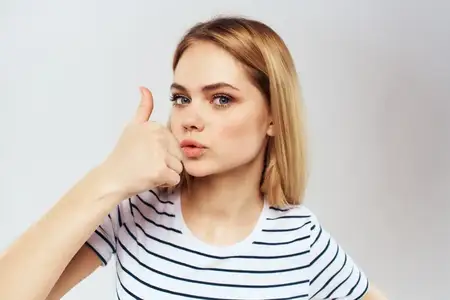 Эмоциональная женщина в полосатой футболке жестикулирует руками