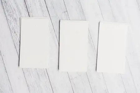 Белые визитные карточки на деревянном фоне, фирменные бланки, вид сверху