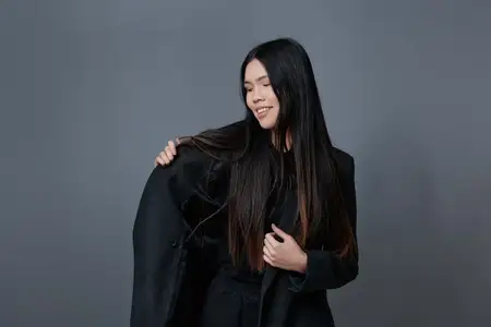 Азиатская модель, воплощающая красоту осени: в пальто, с модной прической, улыбающаяся и стильная