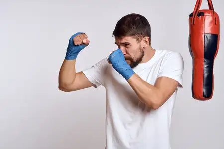 Спортивный автомобиль, боксёрская груша, бинты на руках, упражнение