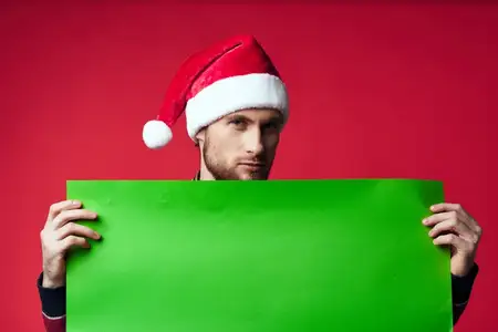 Красивый мужчина в новогодней одежде позирует в студии, оставляя место для рекламного текста