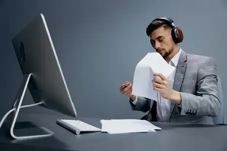 Менеджер работает за компьютером в наушниках в офисе