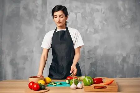 Женщина на кухне нарезает овощи на разделочной доске