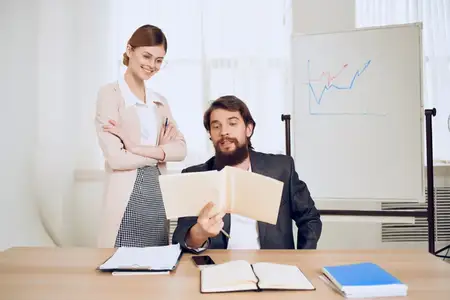 Мужчина и женщина в офисе работают в команде, общаясь друг с другом