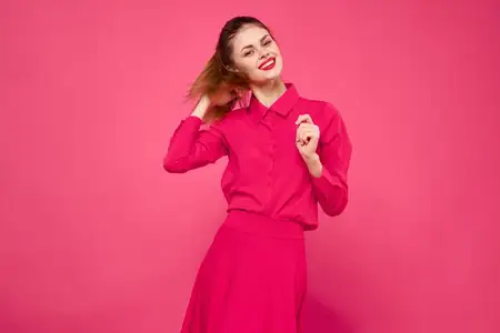 Портрет рыжеволосой женщины в яркой одежде на розовом фоне