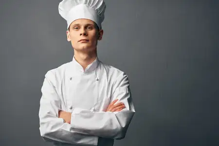 Шеф-повар профессионально работает в ресторане, занимаясь приготовлением пищи
