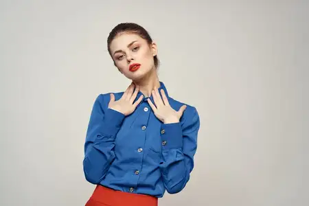 Портрет красивой женщины с красными губами на светлом фоне, в синей рубашке, обрезанный вид