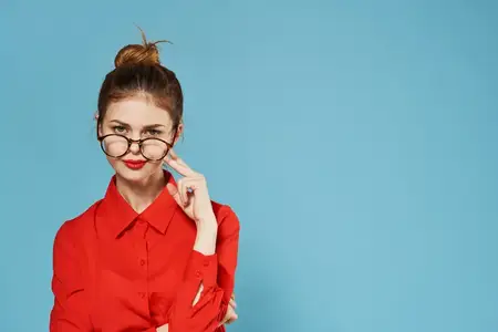 Элегантная женщина в красной рубашке на официальном синем фоне