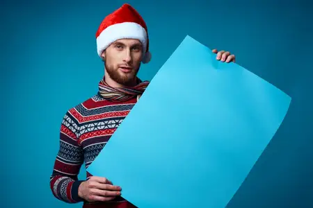 Весёлый мужчина в шапке Санты держит праздничный баннер на изолированном фоне