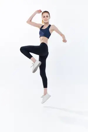 Спортивная женщина прыгает, занимаясь бегом и фитнесом