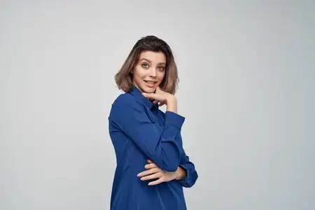 Деловая женщина в синей рубашке в студии на изолированном фоне