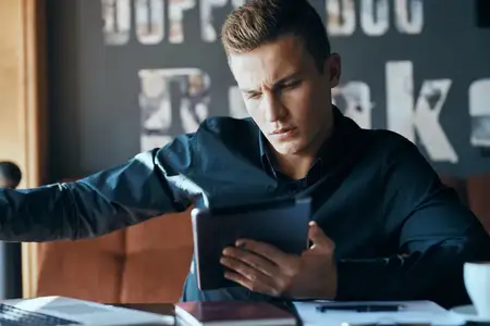 Бизнесмен, фрилансер с ноутбуком в кафе за столом, менеджер, документы, чашка кофе, модель