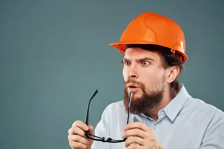 Эмоциональные рабочие в оранжевой краске, работающие в промышленности с соблюдением техники безопасности