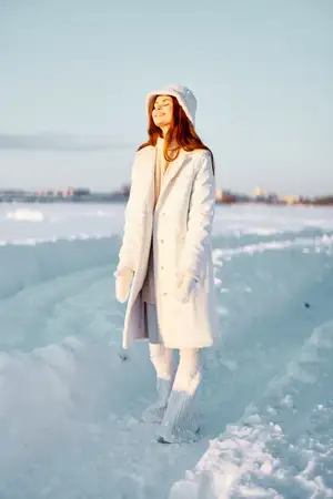 Молодая женщина в белом пальто и шапке на зимнем пейзаже, прогулка, путешествие