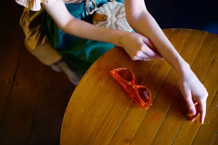 Женщина сидит в кафе, очки лежат на столе, она отдыхает