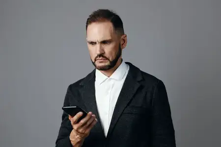Портрет запечатлел исполнительное настроение решимости и спокойствия, отражающее современную рабочую жизнь, изолированный на нейтральном цветном фоне, который усиливает профессиональное присутствие