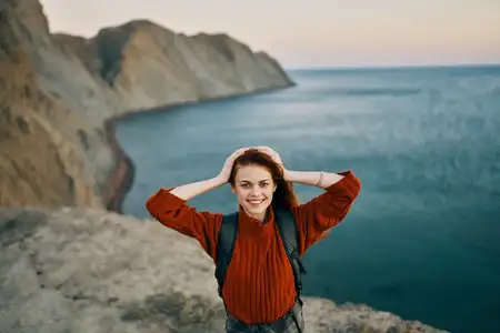 Женщина на фоне осеннего пейзажа: горы, море, пляж, рюкзак, туризм, путешествия, модель