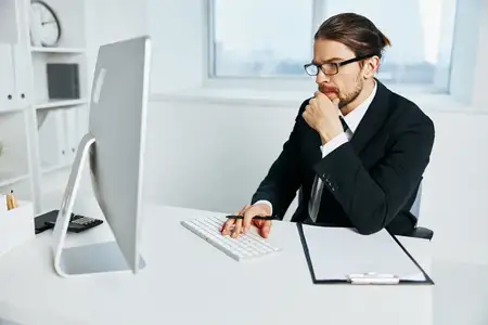 Мужчина в костюме с документами в руках общается по телефону
