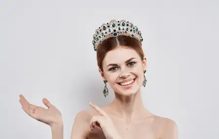Красивая женщина — королева красоты с диадемой, серьгами, модельным макияжем
