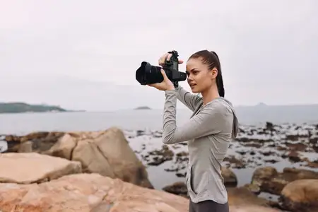 Юная модель занимается фотографией на побережье, запечатлевая безмятежные пейзажи