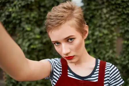 Красивая женщина в парке, среди зелёных кустов, на прогулке на природе