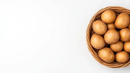 Уютная плетеная корзина, наполненная свежеиспеченными булочками золотисто-коричневого цвета, на белом фоне