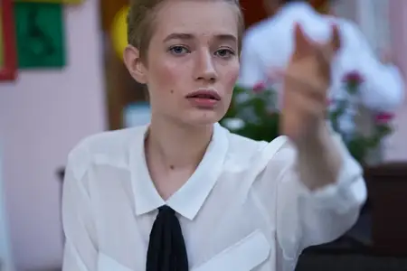 Женщина с короткой стрижкой читает на прогулке, наслаждаясь свежим воздухом