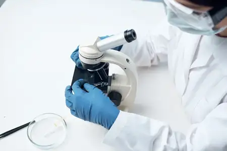 Женщина в медицинской маске работает с микроскопом в лаборатории, научные исследования