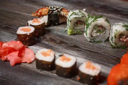 Роллы суши с палочками, японская кухня, доставка еды, обед на деревянном столе
