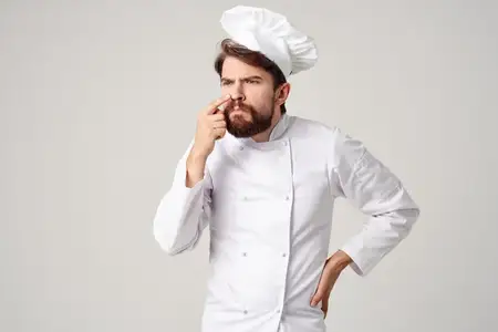 Пекарь работает на кухне, занимаясь выпечкой хлебобулочных изделий в кулинарной индустрии