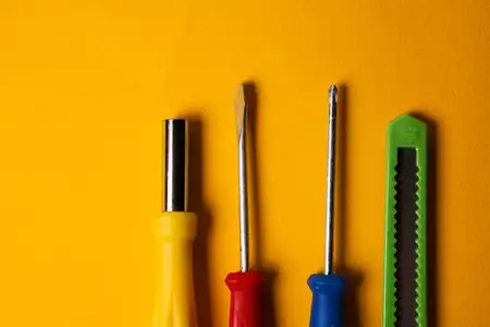 Отвертки и строительные инструменты на желтом фоне, оборудование для ремонтной отрасли