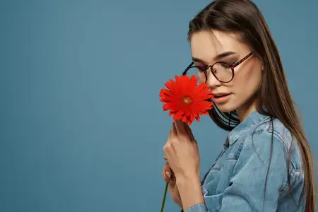 Девушка с цветком возле лица, в очках, гламурный крупный план