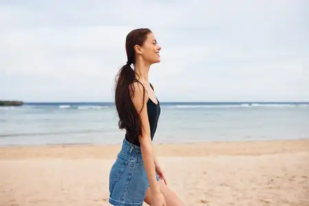 Женщина бежит по пляжу на рассвете