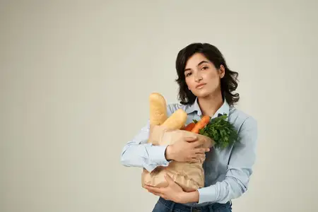 Брюнетка с пакетом продуктов в супермаркете: здоровая еда, овощи, образ жизни