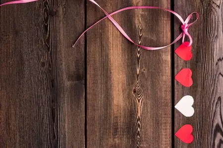 Бумажные сердечки на деревянном фоне, текстура открытки ко Дню святого Валентина