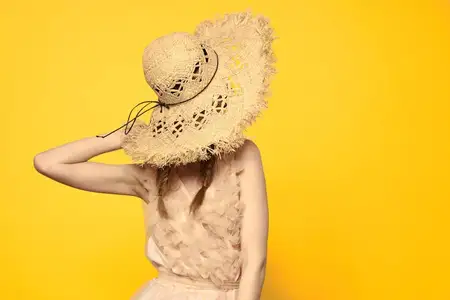 Портрет женщины в соломенной шляпе на желтом фоне