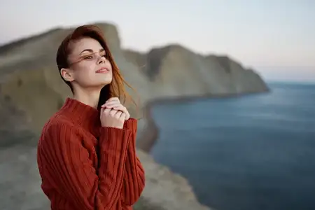 Женщина-туристка с рюкзаком за спиной идет по горному ландшафту