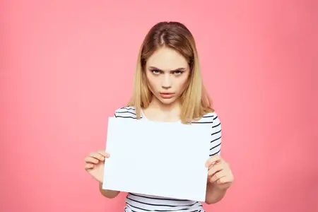 Женщина держит в руках белый лист бумаги