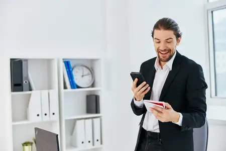 Менеджер за рабочим столом с документами общается по телефону