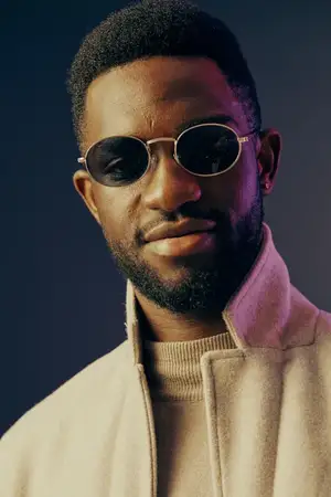 Этот портрет изображает модного африканского мужчину в круглых солнцезащитных очках, излучающего уверенность