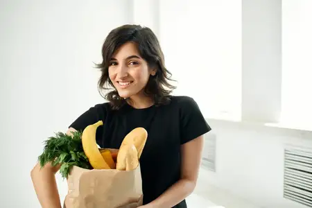 Весёлая брюнетка с сумкой для продуктов, доставка здоровой пищи, овощи