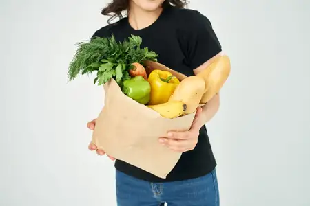 Пакет с продуктами, овощи из супермаркета на светлом фоне