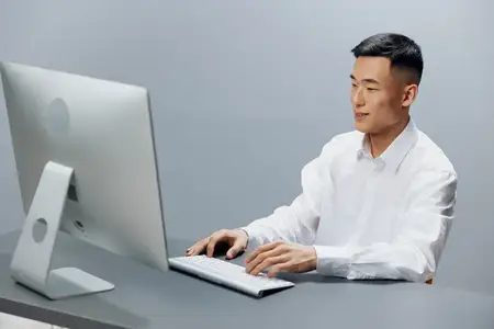 Бизнесмен в белой рубашке работает за компьютером в офисе