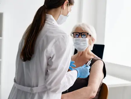 Медсестра делает укол пожилой женщине, вакцинный паспорт, эпидемия COVID-19