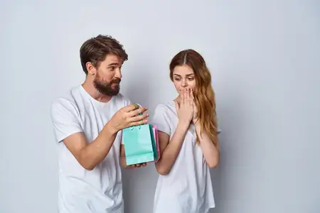 Мужчина и женщина с подарками, образ жизни, веселье, мода на светлом фоне