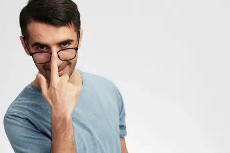 Портрет мужчины в синей футболке и очках для зрения, на его лице улыбка и эмоции, крупный план