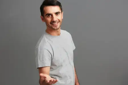 Веселый мужчина позирует и жестикулирует руками на изолированном фоне