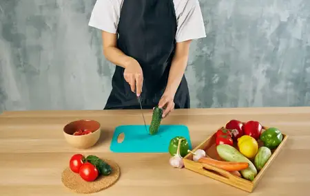 Нарезка свежих овощей на разделочной доске, приготовление пищи на кухне, здоровая еда